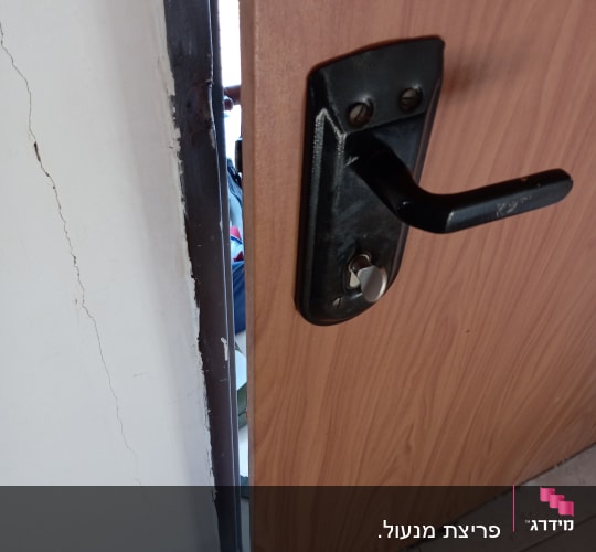 ידית דלת ומנעול על דלת עץ פתוחה